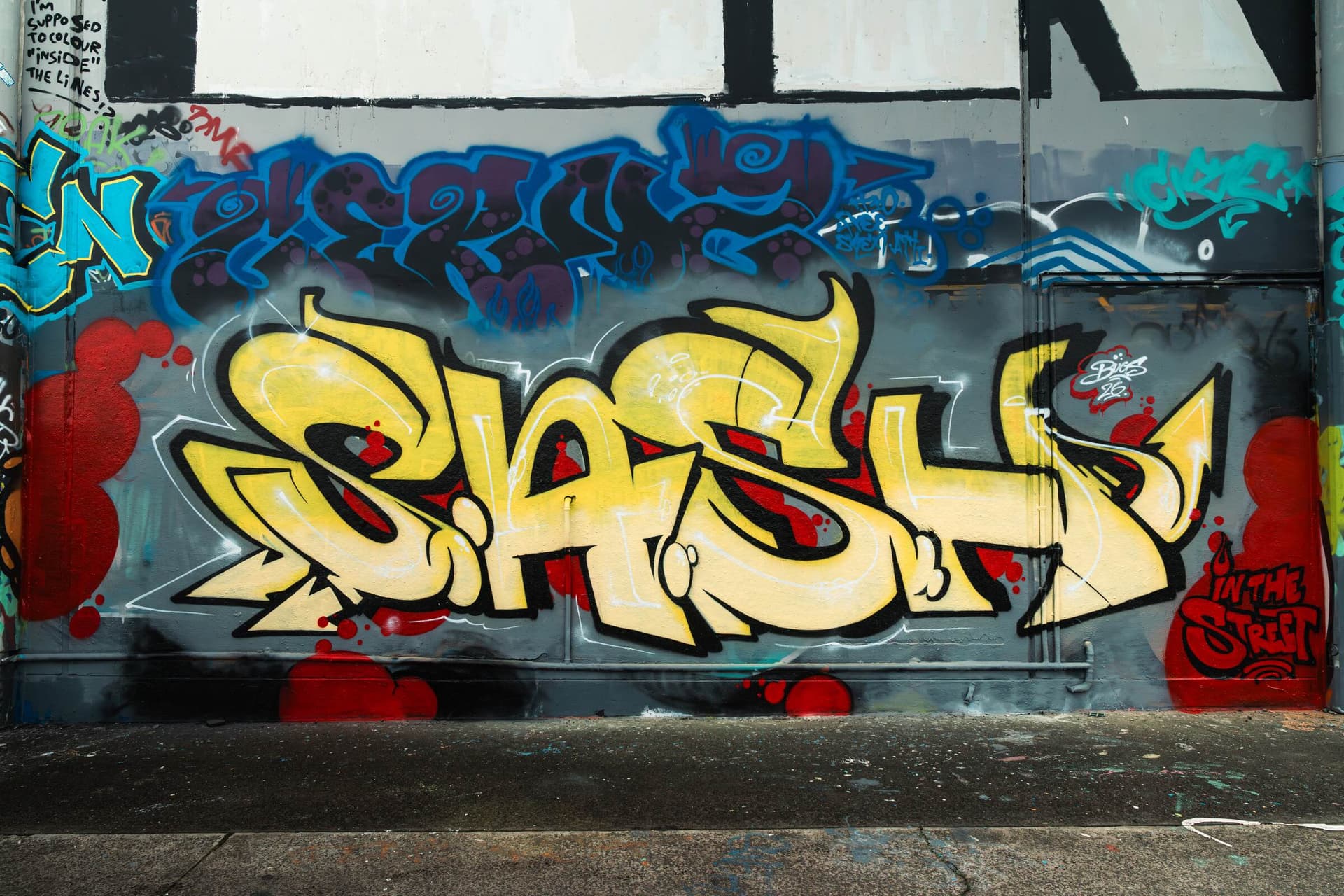 S.A.S.H graffiti painted across a Sydney laneway wall